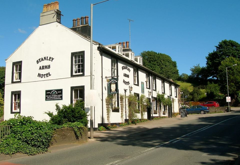 a white building with black lettering on the side is situated on a street corner at Stanley Arms Hotel