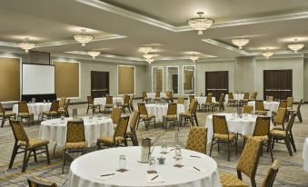 a large , well - lit conference room with multiple round tables and chairs , set for a meeting or event at Sheraton Valley Forge King of Prussia