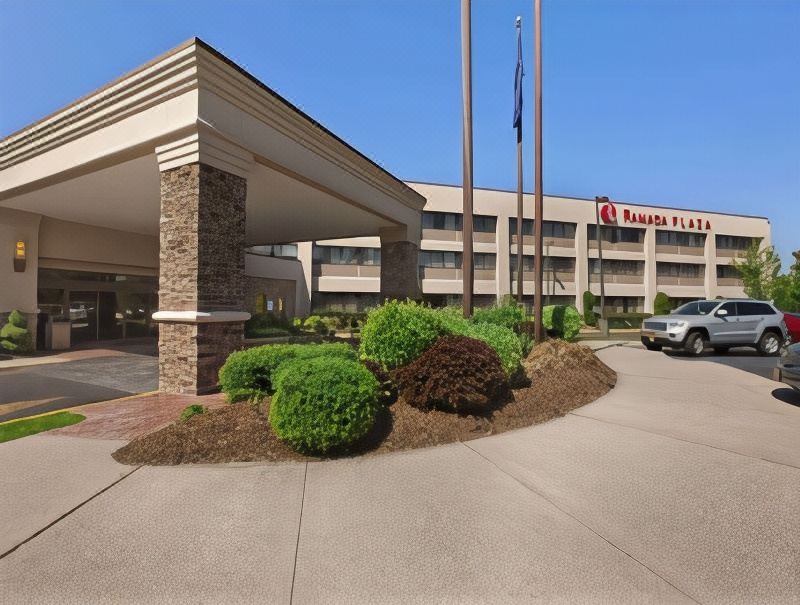 a large hotel building with a parking lot in front of it , providing a safe and comfortable environment for guests at Holiday Inn Long Island - Islip Arpt East
