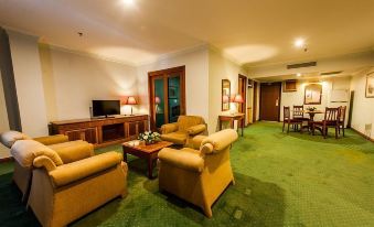 a spacious living room with green carpeting , several chairs , and a television on the wall at StarLodge