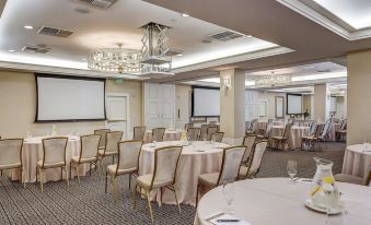 a large conference room with multiple round tables and chairs arranged for a meeting or event at El Prado