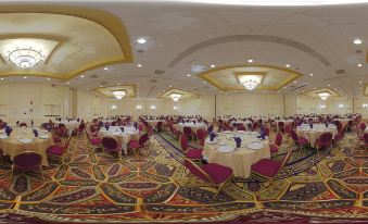 a large banquet hall filled with round tables and chairs , ready for a formal event at Winston-Salem Marriott