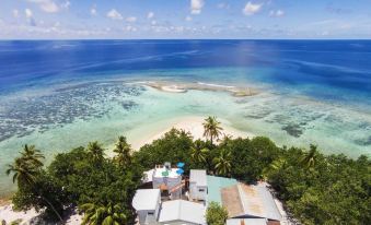 a tropical beach with clear blue water and white sandy beaches , as well as several buildings on the shore at Liberty Guesthouse Maldives