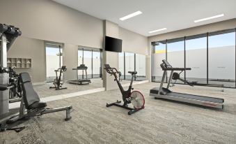 a well - equipped gym with various exercise equipment , including treadmills and weightlifting machines , as well as a tv mounted on the wall at Quest Innaloo