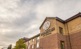 "a brick building with the word "" doubletree "" prominently displayed on the side , and a cloudy sky in the background" at DoubleTree by Hilton Swindon