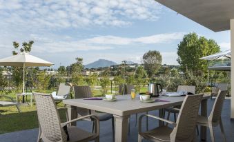 a patio table with chairs and a view of a mountainous landscape in the background at Suite Home Porticcio