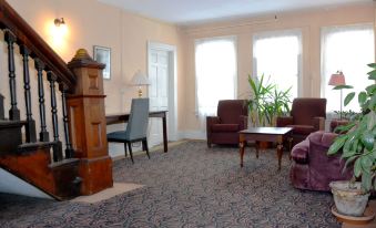 a spacious living room with carpeted floors , two couches , and a fireplace , all arranged in a comfortable setting at Hotel Coolidge