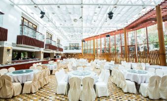 a large banquet hall with multiple dining tables and chairs set up for a formal event at Alishan House