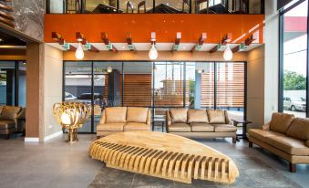 a modern living room with orange walls , large windows , and various pieces of furniture such as a couch , coffee table , and bookshelf at Villa Baron