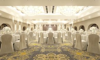 a large banquet hall with white chairs and tables set up for a formal event at Pearl Hotel