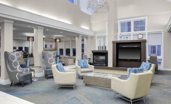 a large , modern hotel lobby with a comfortable seating area and a fireplace , surrounded by comfortable chairs and a fireplace at Residence Inn Richmond Chester