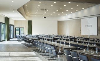 a large conference room with multiple rows of chairs arranged in a semicircle , creating an auditorium - like setting at Camiral Golf & Wellness - Leading Hotel of the World