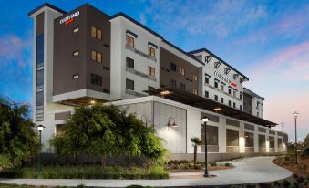 "a large hotel building with a courtyard sign that says "" hotel "" is surrounded by trees" at Courtyard Redwood City