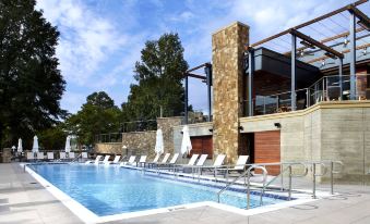 a large outdoor swimming pool surrounded by lounge chairs and umbrellas , providing a relaxing atmosphere at Raleigh Marriott Crabtree Valley
