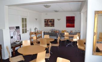 a large room with several tables and chairs arranged for a group of people to sit and eat at Barossa Gateway Motel