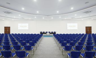 a large , empty conference room with rows of blue chairs and white walls , set up for a presentation or meeting at Diamonds Dream of Africa