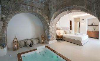 a bedroom with a bed and a bathtub in the middle of the room , surrounded by white walls at Masseria Amastuola Wine Resort