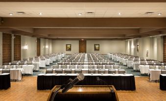 a large conference room filled with rows of chairs and tables , a podium at the front , and a microphone on each table at Lodge of Four Seasons Golf Resort, Marina & Spa