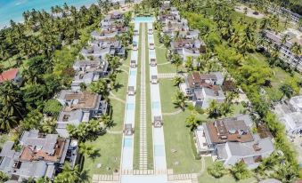 a bird 's eye view of a resort with a pool , surrounded by palm trees and grass at Small Luxury Hotels of the World - Sublime Samana Hotel & Residences