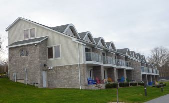 a row of multi - story townhouses with balconies and stone exteriors , situated on a grassy area at Oak Island Resort & Conference Centre