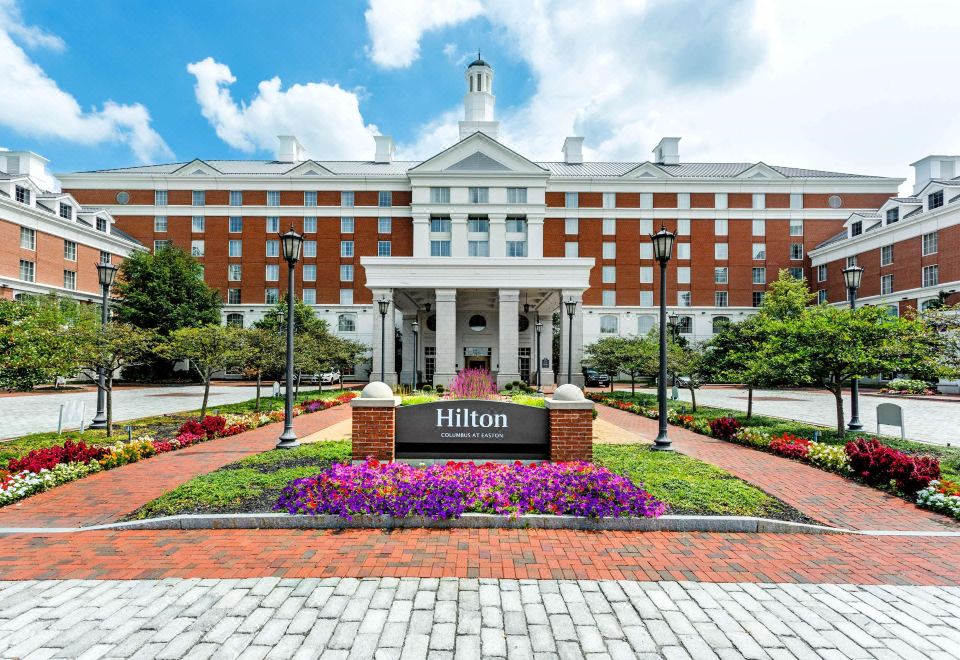 "a large brick building with a white sign that reads "" hilton "" prominently displayed on the front of the building" at Hilton Columbus at Easton