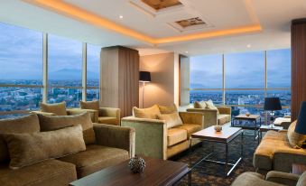 a modern living room with a large window overlooking the city , featuring comfortable furniture and a coffee table at Best Western Premier la Grande Hotel
