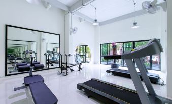 a well - equipped gym with various exercise equipment , such as treadmills , weight machines , and benches , along with a yoga mat at Soho Boutique Hotel