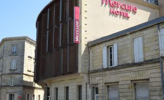 "a modern building with a curved facade and the word "" mercure "" written on it , under a clear blue sky" at Mercure Libourne Saint Emilion