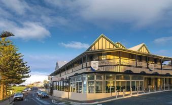 a large building with a brown roof and glass windows is situated on a street corner at Aurora Ozone Hotel Kangaroo Island