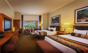 a hotel room with two beds , nightstands , and a large window offering a view of the outdoors at Pala Casino Spa and Resort