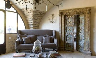 a cozy living room with a large window , a couch , and a dining table surrounded by chairs at Le Clos Saint Saourde