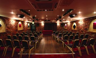 a well - lit auditorium with rows of chairs arranged in a symmetrical pattern , ready for a concert or event at Best Western Bradford Guide Post Hotel