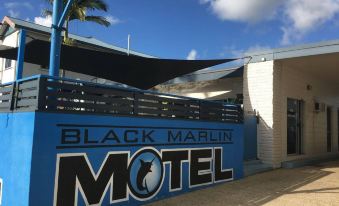 "a blue and white motel building with a sign that reads "" black marlin motel "" prominently displayed on the building" at Black Marlin Motel