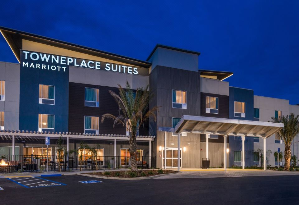 "a modern hotel building with the name "" boulevard suites "" displayed above its entrance , illuminated at night" at TownePlace Suites Merced