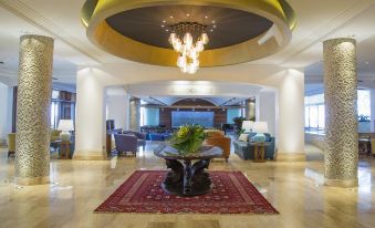 a spacious lobby with high ceilings , multiple potted plants , and a large chandelier hanging from the ceiling at Columbia Beach Resort