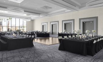 a large , empty banquet hall with black tables and chairs set up for a formal event at Courtyard Dallas Flower Mound