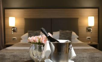 a hotel room with a bed and a tray of champagne bottles on the bed at Hotel Princess
