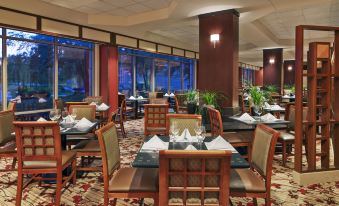 a large dining room with multiple tables and chairs arranged for a group of people to enjoy a meal at Sheraton Suites Chicago Elk Grove