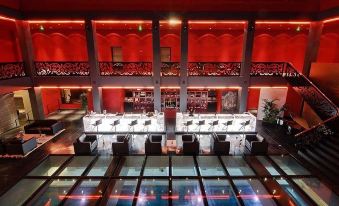 a large , modern hotel lobby with multiple couches and chairs arranged around a dining table at Hotel de Bourgtheroulde, Autograph Collection