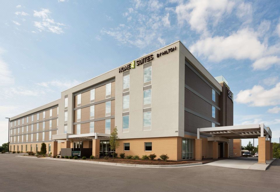 "a large building with the words "" sleep inn & suites "" prominently displayed on its side" at Home2 Suites by Hilton Milwaukee Brookfield