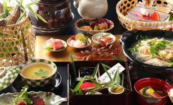 a dining table set with a variety of food items , including bowls , cups , and utensils at Fuefukigawa Onsen Zabou
