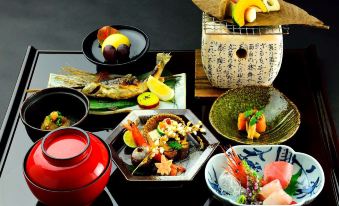 a dining table with a variety of food items , including bowls , plates , and utensils , placed on it at Ryugon