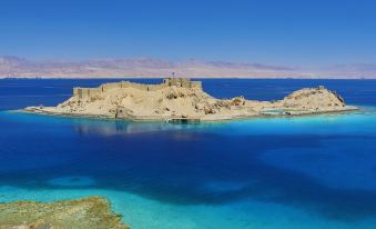 a breathtaking view of the ancient ruins of an ancient city , surrounded by clear blue water and rocky terrain at Steigenberger Hotel & Nelson Village, Taba