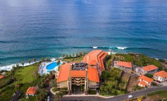aerial view of a large building with orange roofs overlooking the ocean , surrounded by lush greenery at Monte Mar Palace Hotel