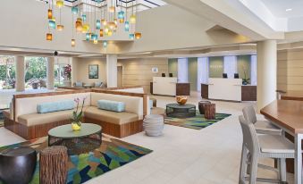 a modern hotel lobby with a couch , chairs , and a reception desk under a colorful light fixture at The Westin St. John Resort Villas