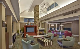 a large hotel lobby with multiple couches , chairs , and tables arranged for guests to relax and socialize at Residence Inn Waldorf