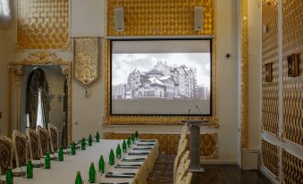 a conference room with a long table , green bottles , and a projector screen displaying an image of a building at Green House