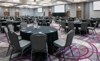 a large conference room with round tables and chairs arranged for a meeting or event at Courtyard Omaha Bellevue at Beardmore Event Center