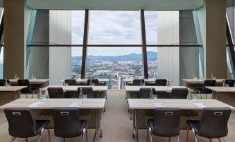 The room offers a scenic view through its large windows and is furnished with tables in the center at Element Kuala Lumpur