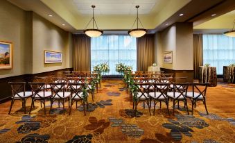 a room with chairs and tables set up for a wedding ceremony , surrounded by flowers at Hyatt Regency Calgary